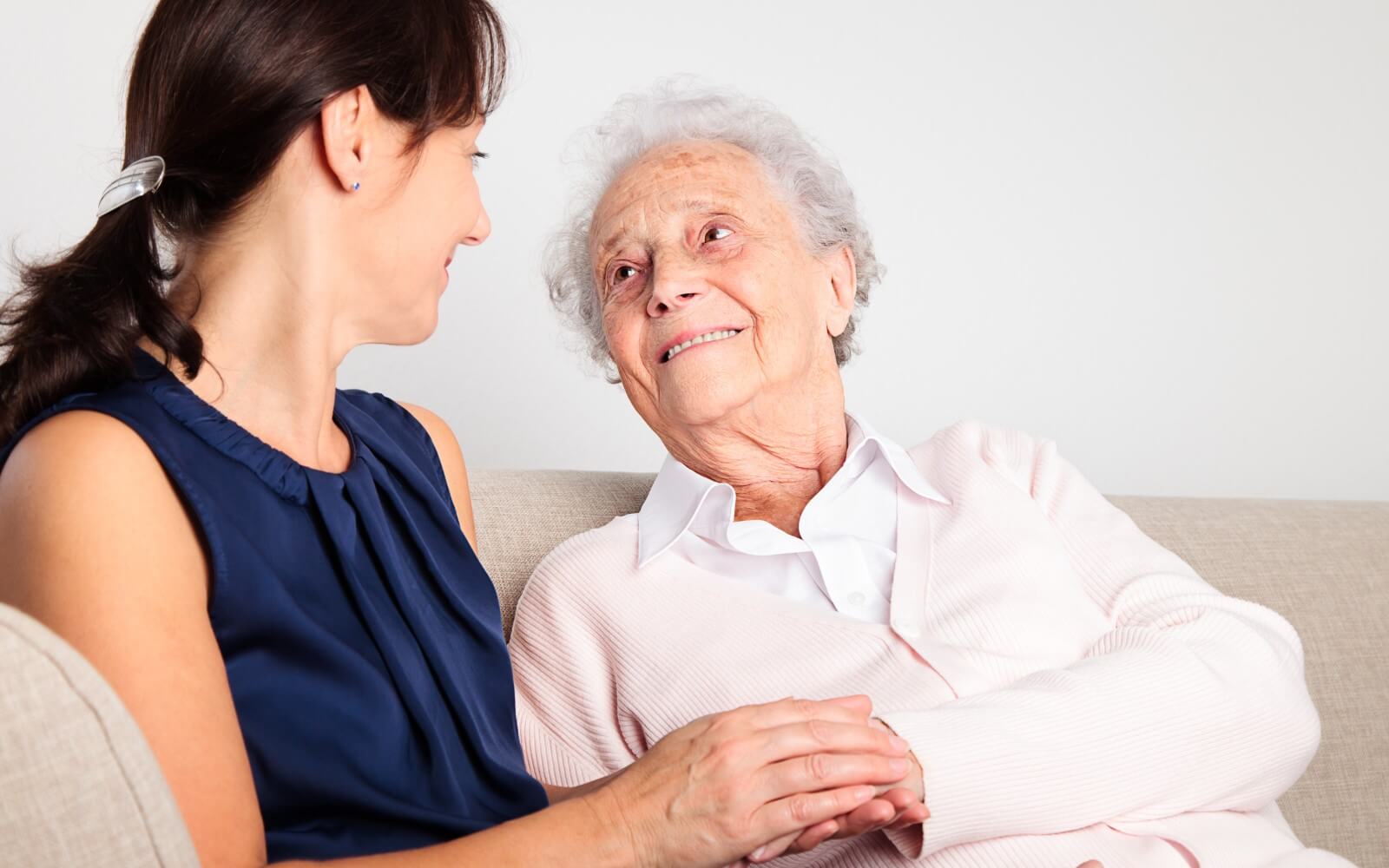 Pflegekraft im Gespräch mit an Demenz erkrankter Seniorin