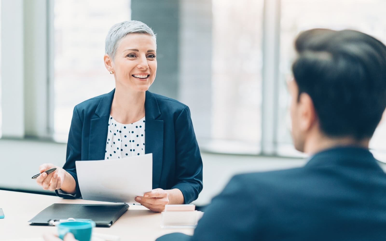 Bewerbungsgespräch zwischen Personalleiterin und Bewerber.